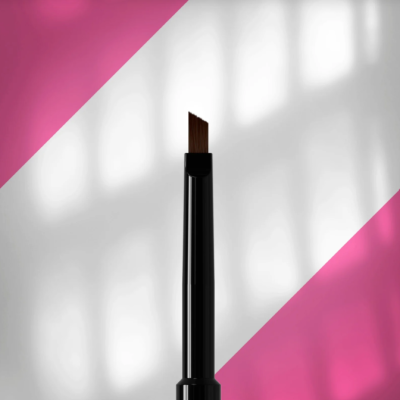 Pincel angular preto com cerdas castanhas sobre fundo branco e cor-de-rosa