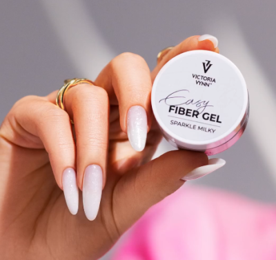Frasco pequeno redondo de gel para unhas VICTORIA VYNN EASY FIBER GEL SPARKLE MILKY na mão com unhas brancas brilhantes