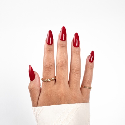 Mão com unhas vermelhas e anéis dourados