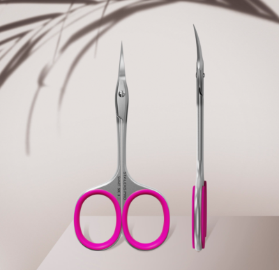 Tesouras pequenas em metal com encaixes rosa sobre superfície clara