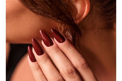 Unhas castanhas escuras brilhantes compridas em mão feminina