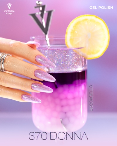 Unhas com verniz gel lilás glitter segurando copo com bebida rosa e roxa e rodela de limão