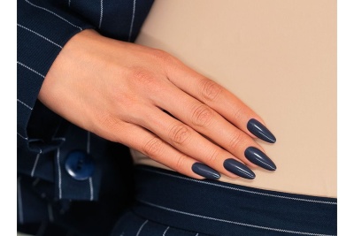 Mão com unhas azul escuro e roupa azul riscada