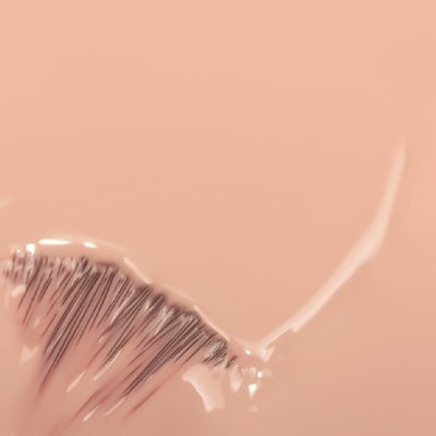 pincel com cerdas finas sobre textura cremosa cor de pele