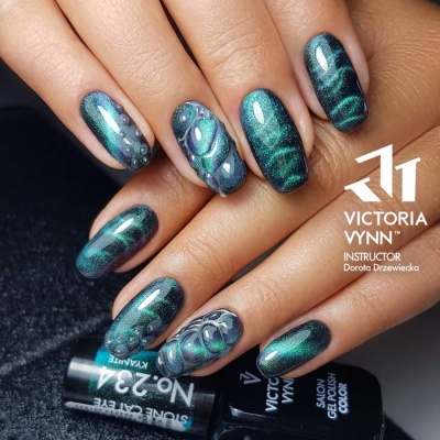 Unhas com verniz gel verde metálico e decoração 3D sobre frascos de verniz