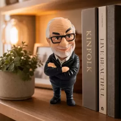 Figura decorativa de homem idoso com óculos em prateleira junto a livros e planta