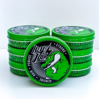 Latas verdes de pomada para cabelo Hey Joe com desenho de crocodilo