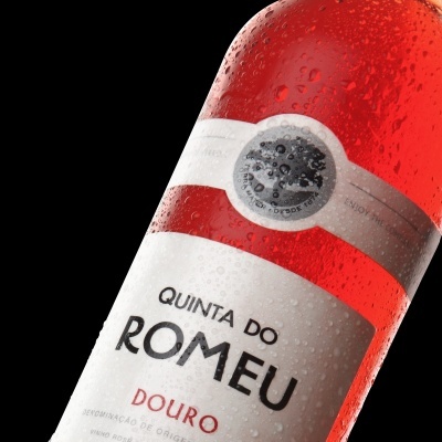 Garrafa de vinho rosé Quinta do Romeu com rótulo branco e vermelho e gotas de água