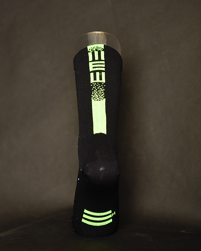 Meias Pretas e Fluor Meia preta com padrão verde fluorescente num suporte transparente