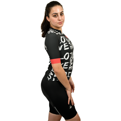 Modelo com camisola de ciclismo preta com texto 'LOVE' e calções pretos, em fundo branco
