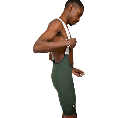 Homem com calções de ciclismo verdes escuros e alças brancas em fundo branco