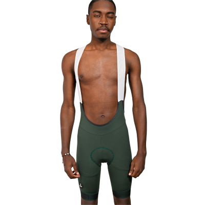 Homem a usar calções de ciclismo verdes com suspensórios brancos e assento acolchoado