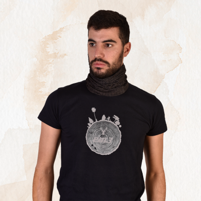 Homem com t-shirt preta estampada e cachecol preto cinzento num fundo claro texturizado