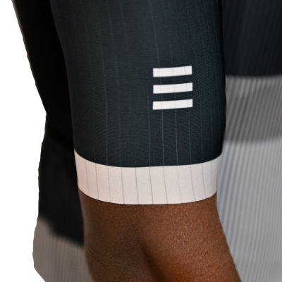 Manga de roupa desportiva azul escura com riscas verticais brancas, punho branco e três barras horizontais brancas.