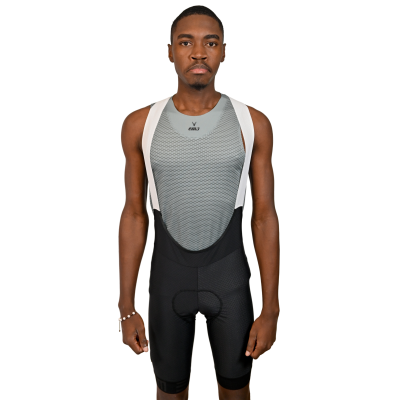 Homem em roupa de ciclismo com top cinza e alças brancas sobre fundo branco