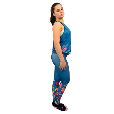 Mulher com roupa desportiva azul com padrão de folhas coloridas