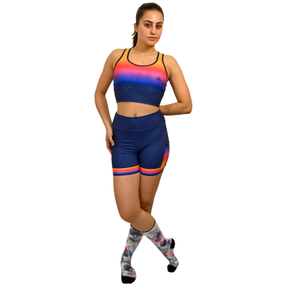 Conjunto desportivo azul com degradê rosa e laranja e meias brancas com padrões coloridos.