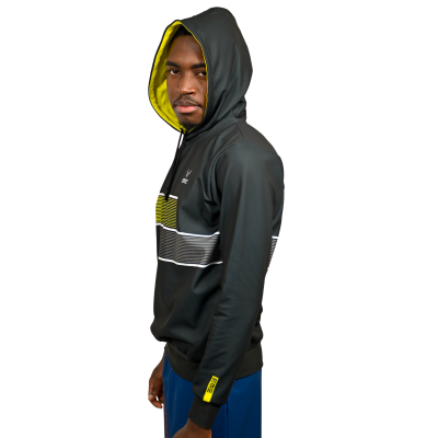 Homem com hoodie preto e capuz amarelo, faixas horizontais no peito e calças azuis