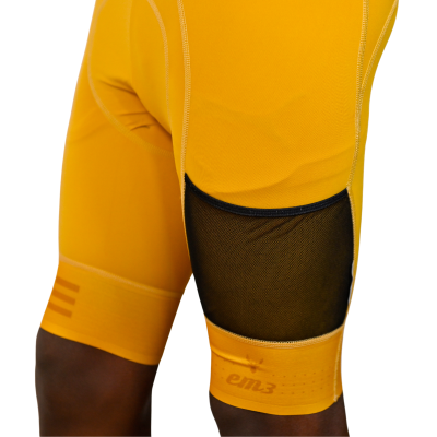 Calções desportivos amarelos com painel preto em rede e texto 'em3'