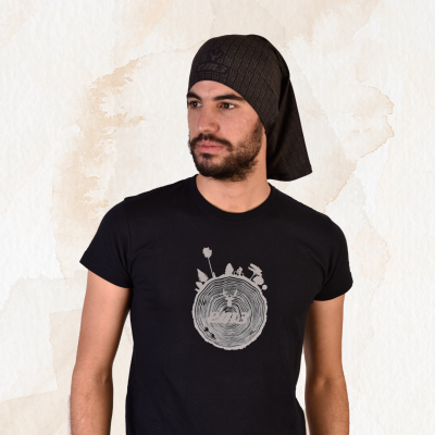 Homem a usar t-shirt preta com estampa cinzenta e lenço preto na cabeça em fundo claro