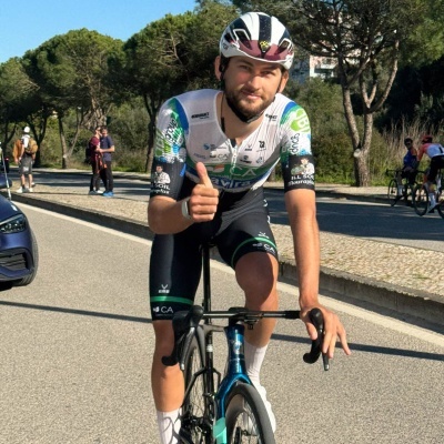 Ciclista com capacete e fato de ciclismo em bicicleta de estrada