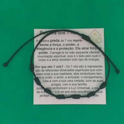 Pulseira preta com contas sobre papel com texto em português