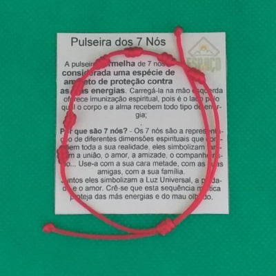 Pulseira vermelha de 7 nós com cartão explicativo sobre fundo verde