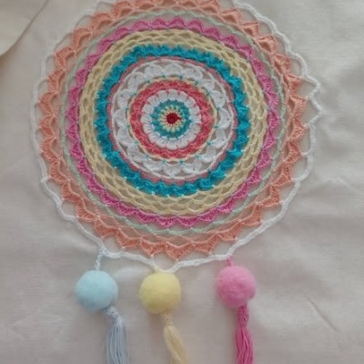 Apanhador de sonhos colorido em linha com pompons e franjas