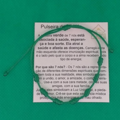 Pulseira verde de cordão com 7 nós sobre cartão explicativo