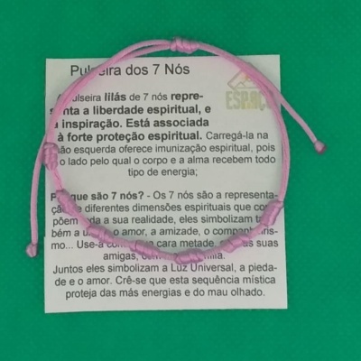 Pulseira lilás com sete nós sobre cartão explicativo em fundo verde