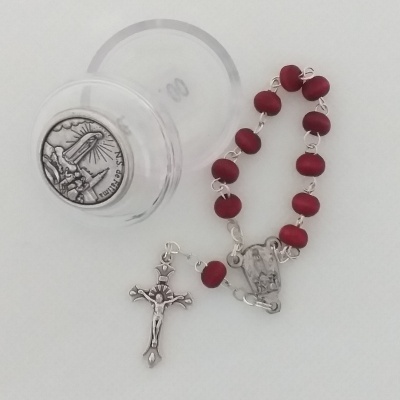 Rosário com contas vermelhas, crucifixo prateado e caixa plástica transparente com medalha de N.S. de Fátima