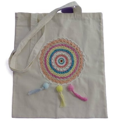 Saco de pano bege com decoração em croché colorida e pompons