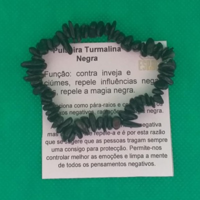Pulseira de pedras pretas sobre cartão branco com texto em português