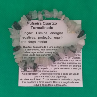 Pulseira de cristais brancos e verdes sobre papel com texto