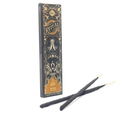 Caixa de incenso Ritual em preto e dourado com dois bastões de incenso pretos.