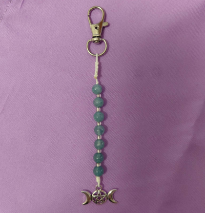 Chaveiro com fecho metálico, contas azuis e pendente com pentagrama e luas crescentes