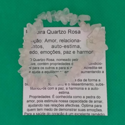 Pulseira de pedras brancas sobre papel com texto sobre Quartzo Rosa em fundo verde