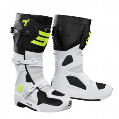 Botas de motocross brancas, pretas e verdes com fivelas ajustáveis.