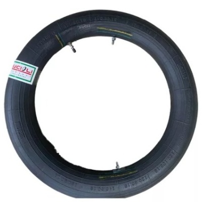 Pneu de borracha preto com válvula e etiqueta sobre fundo branco