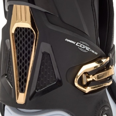 Bota esportiva preta com detalhes dourados metálicos e fecho lateral