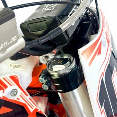 Suspensão dianteira de motocicleta com componentes metálicos e plásticos nas cores branco, preto e vermelho