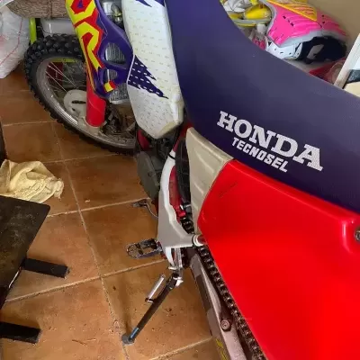 Motocross Honda com assento azul escuro e carenagem vermelha