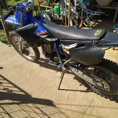 Motocross azul e preto com logótipos e pneus cravados em espaço exterior