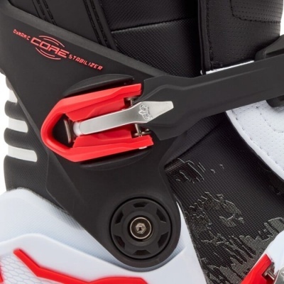 Detalhe de bota desportiva preta branca e vermelha com fivela e texto CORE STABILIZER