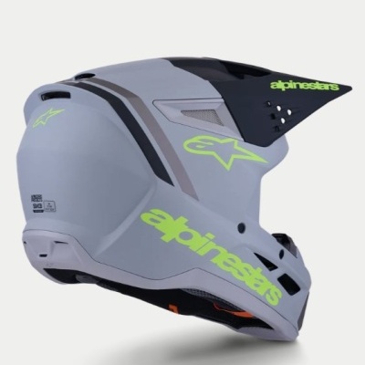 Capacete integral motocross cinza com logos verdes alpinestars e viseira preta