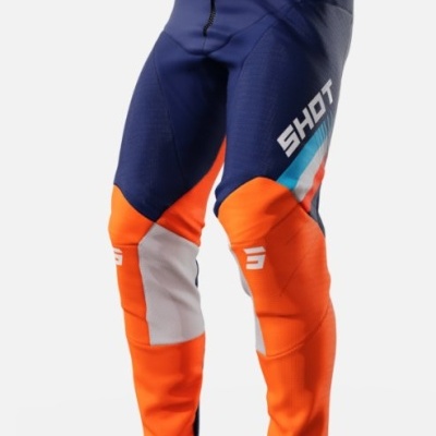 Calças motocross azul escuro, laranja e cinzento com texto 'SHOT' em branco