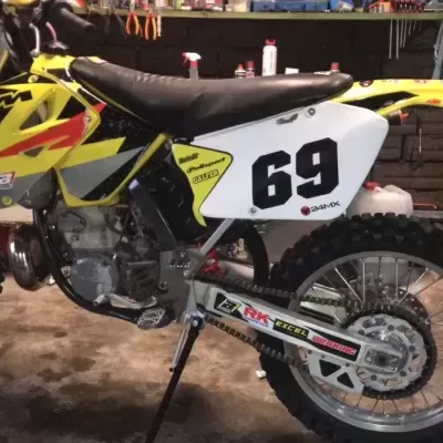 Motocross amarelo e branco com número 69 em oficina