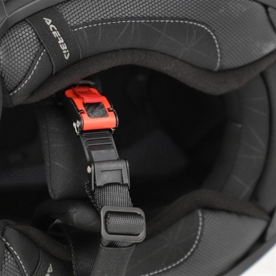Interior de capacete preto com fivela de segurança vermelha e etiqueta Acerbis.