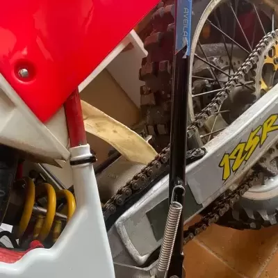 Peças de uma mota de terra com texto 125SR e AVELLAR