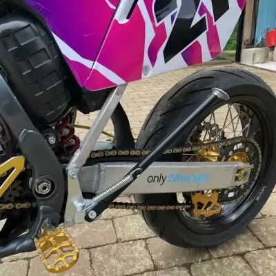 Parte traseira de mota desportiva com número 21 e detalhes em preto, roxo, branco e dourado